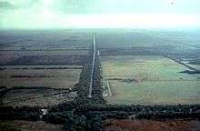 Aerial view of agricultural fields through the middle of which is a drainage canal