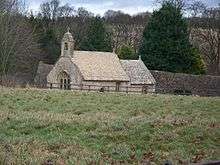 A small, simple church seen from a distance showing the nave with a single bellcote, and a smaller chancel beyond