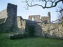 Ruined stone walls with one intact window frame.