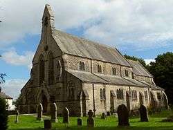 19th century stone church with side aisles and bell gable