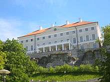 Stenbock House gray stucco three story building with pediment and portico and red hip roof