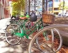 A step through ladies bicycle and other bikes parked on the street.