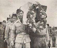 A line of men carrying a casket