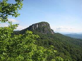 A huge rock on top of a mountain with a flat top