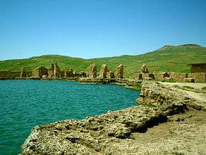 Ruins of buildings near a lake.