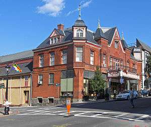 An ornate brick building with several capped towers. A marquee on the front has large lettering that reads "Music Hall"