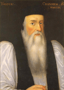 Portrait of Archbishop Cranmer as an elderly man. He has a long face with a flowing white beard, large nose, dark eyes and rosy cheeks. He wears clerical robes with a black mantle over full white sleeves and has a doctoral cap on his head