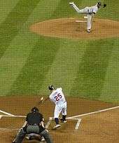 The moment of contact between Thome's bat and a pitch from Fausto Carmona; the image is distorted through the black screen protecting those sitting behind home plate.