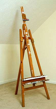 Wooden easel standing in empty room.