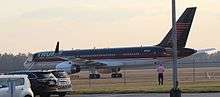 A Boeing 757 with blue, red, and white livery, idling on a runway. This plane belongs to Trump, who nicknamed it "Trump Force One" during Trump's 2016 presidential campaign.