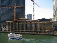 the first few floors of construction of a building from across a river