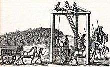 A monochrome illustration of a three-legged structure, with beams connecting each leg along the top (forming an equilateral triangle, on its side).  Several men are sitting at the top of the structure, near a ladder, about 20 feet above the people below.  A rope connects the top of the structure to the neck of a man, stood on a horsecart.  Another man is reading from a book, in his direction.  Horses pull another cart, on which two coffins can be seen.  A large crowd is gathered on the horizon, watching the scene.