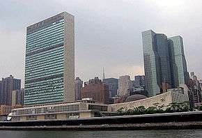 Two skyscraper buildings on the bank of a river.