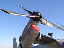 A closeup of a MV-22B's rotor and engine tilted slightly upward.