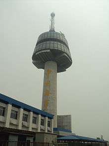 Large mushroom-shaped concrete tower with a smaller white building under it