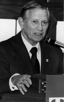 Black-and-white photo of man in a suit and black tie