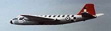 Wide view of jet aircraft. The fin is red; short black stripes running perpendicular to and on top of the fuselage.