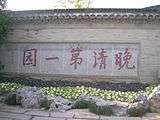 Large inscribed stone with flowers in front