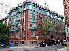 Photograph of a five-story building on a downtown street corner.