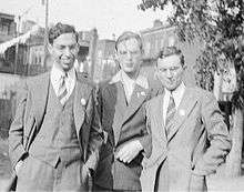 Black-and-white photograph of three men standing together