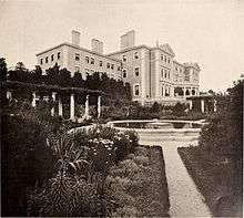 A large square garden in front of a large house