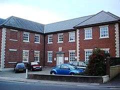 red brick building with small car park in front.