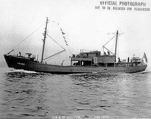 The USS YP-422, a small two-masted vessel with several sailors visible on deck