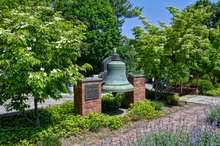 A fire bell on a pedestal in park-like surrounds